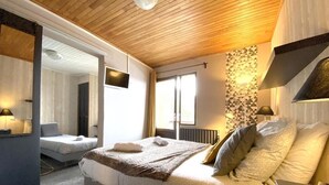 A bedroom with a bed, bedside table, lamp, and a window. - Hotel Le beau Site (Auris)