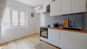 Eine moderne Küche mit weißen Schränken, einer Holzauskastung und einem eingebauten Ofen.