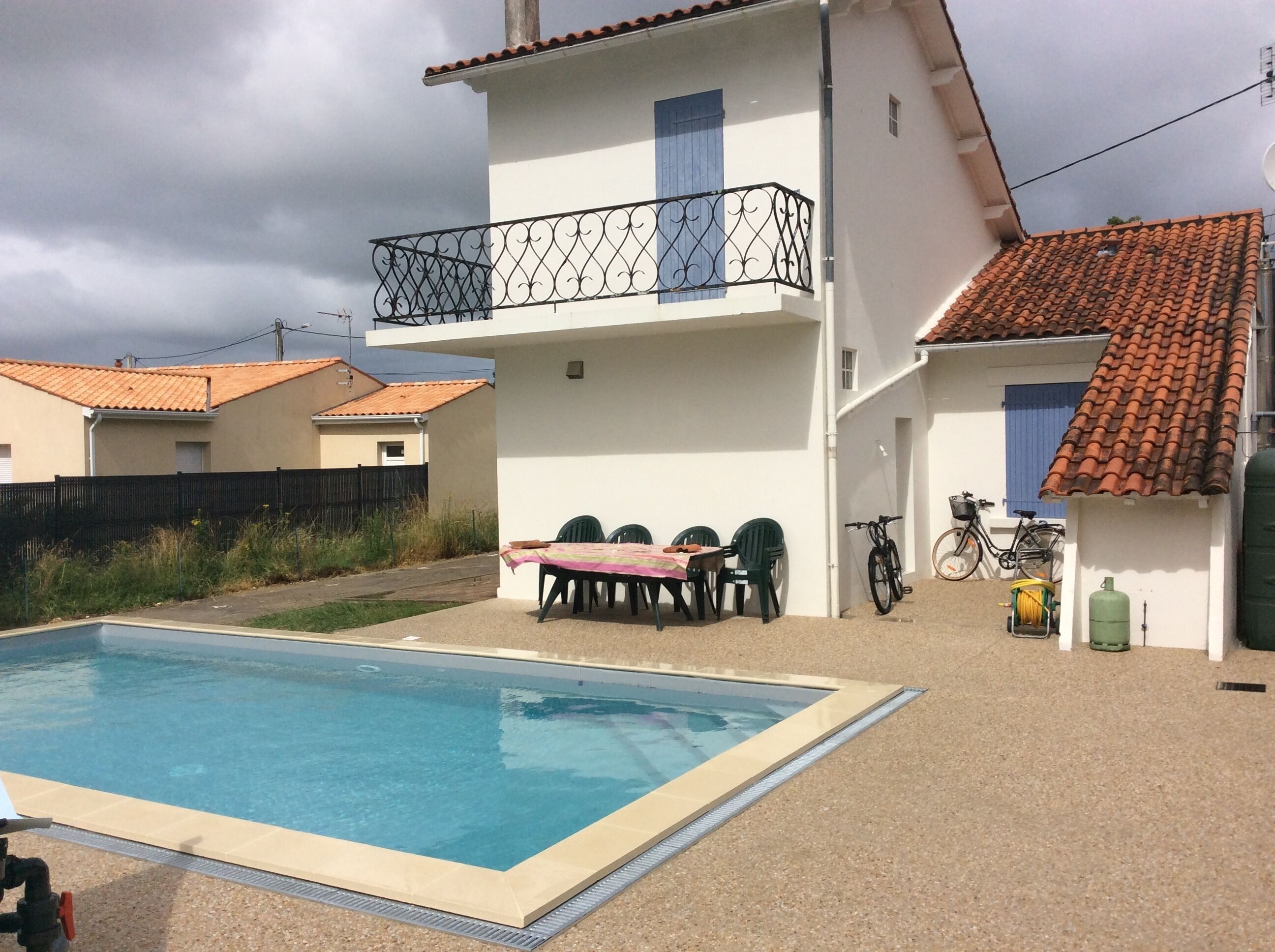 Une propriété résidentielle dotée d’une piscine, d’une table à manger avec des chaises et d’un vélo.