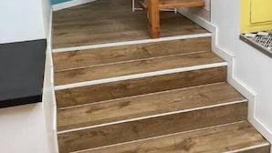 Eine Holztreppe mit weißen Wänden und einer Türkis-farbenen Akzentwand.