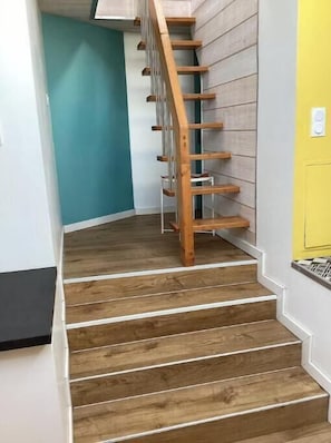 A wooden staircase with white walls and a teal accent wall. - Quiet location between lake and mountains - Apartment with garden near Annecy (Sevrier)