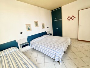 Ein Schlafzimmer mit zwei Betten, einem Kleiderschrank und einer Tür.
