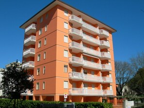 Ein mehrstöckiges Wohngebäude mit Balkonen, einem Verbotsschild und blauem Himmel.