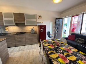 Eine moderne Küche mit Holzausstattung, einem Kühlschrank und einem Essbereich mit bunten Tischdecken.
