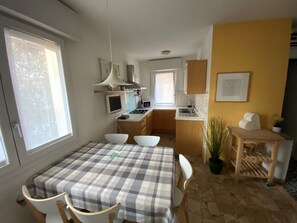 Eine kleine Küche mit Essbereich, einem Tisch und Stühlen.