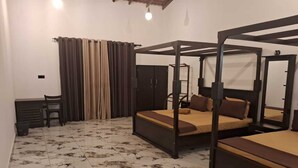 Un dormitorio con dos camas, un escritorio y una silla.