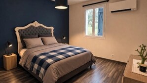 Una camera da letto con un letto, lampade da comodino, una finestra e un condizionatore d'aria.