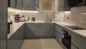 A modern kitchen with a built-in oven, a coffee maker, and a wine rack. - Minutes from tube, exclusive central london location. Huge garden and spacious (London)