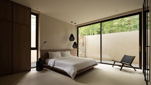 Una camera da letto con un letto, una sedia e un'ampia finestra.