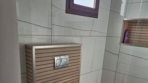 Ein Badezimmer mit Holzpaneelen, einem Fenster und gefliesten Wänden.