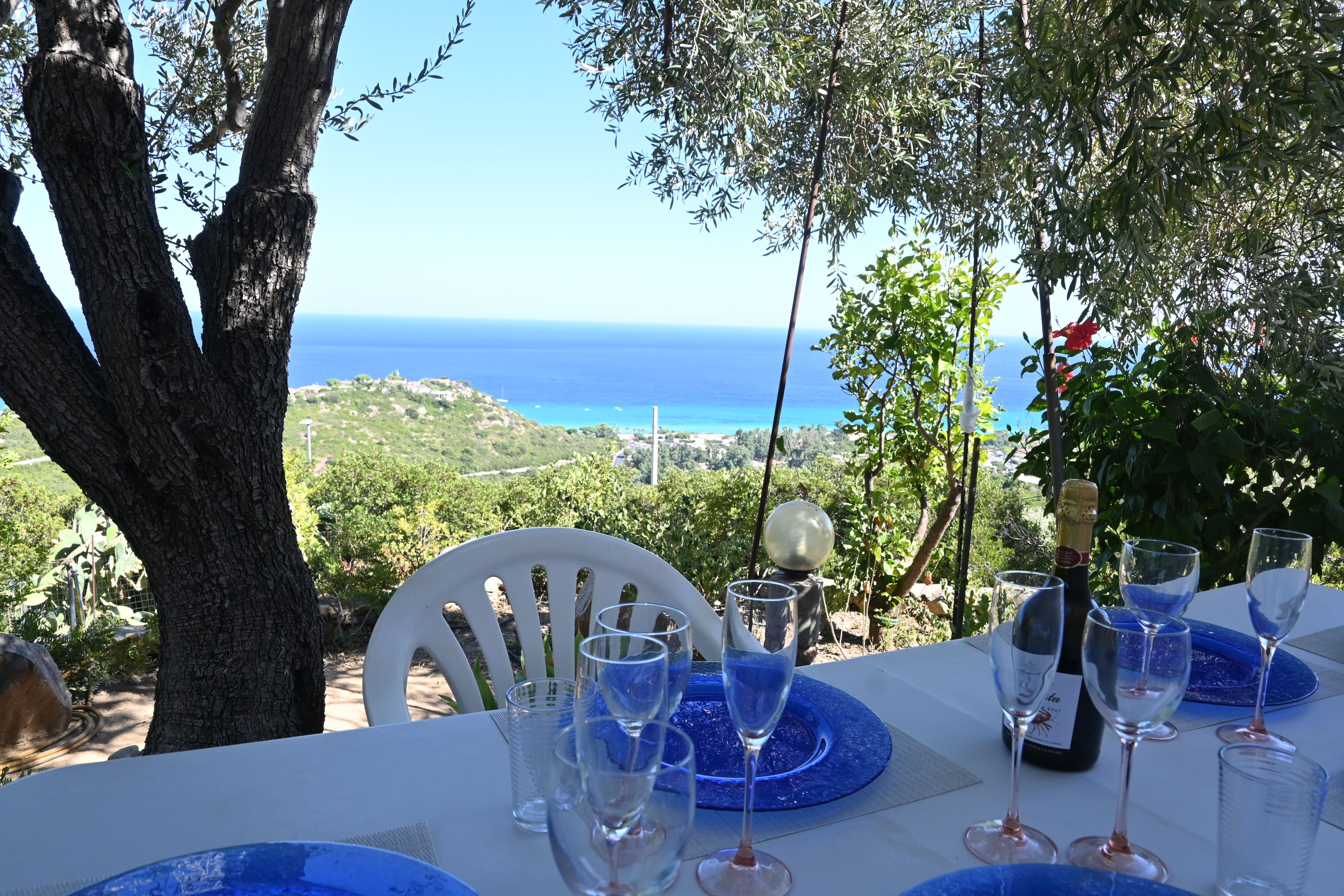 A table set for a meal with a view of the sea.