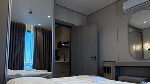 A modern hotel room with a large bed, a mirror, a wardrobe, and a bathroom with a shower. - 301 Tara-jre Jabal Al Lweibdeh With Stunning View (Amman)
