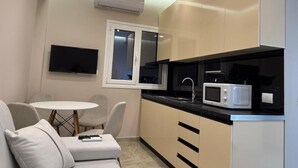Una cocina funcional con microondas, una mesita y un sofá.