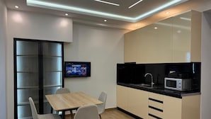 Cocina moderna con comedor, televisor y microondas.