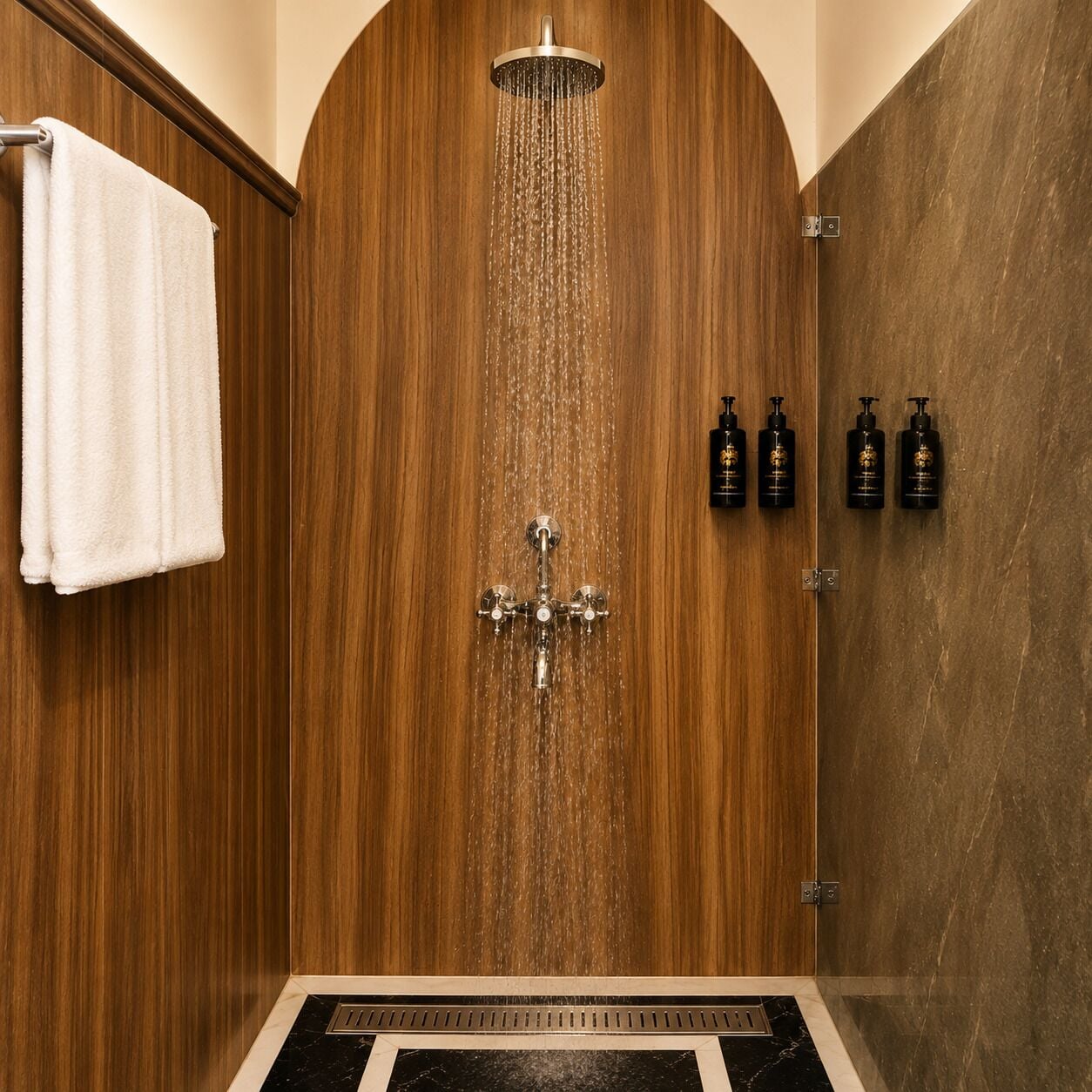 A wooden shower enclosure with a rain showerhead, a towel rack, and three bottles of shampoo.