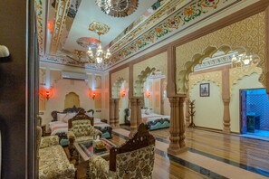 A luxurious room with ornate decor, a large bed, seating area, and a view of the outside. - Mahal Khas Palace (Bharatpur)