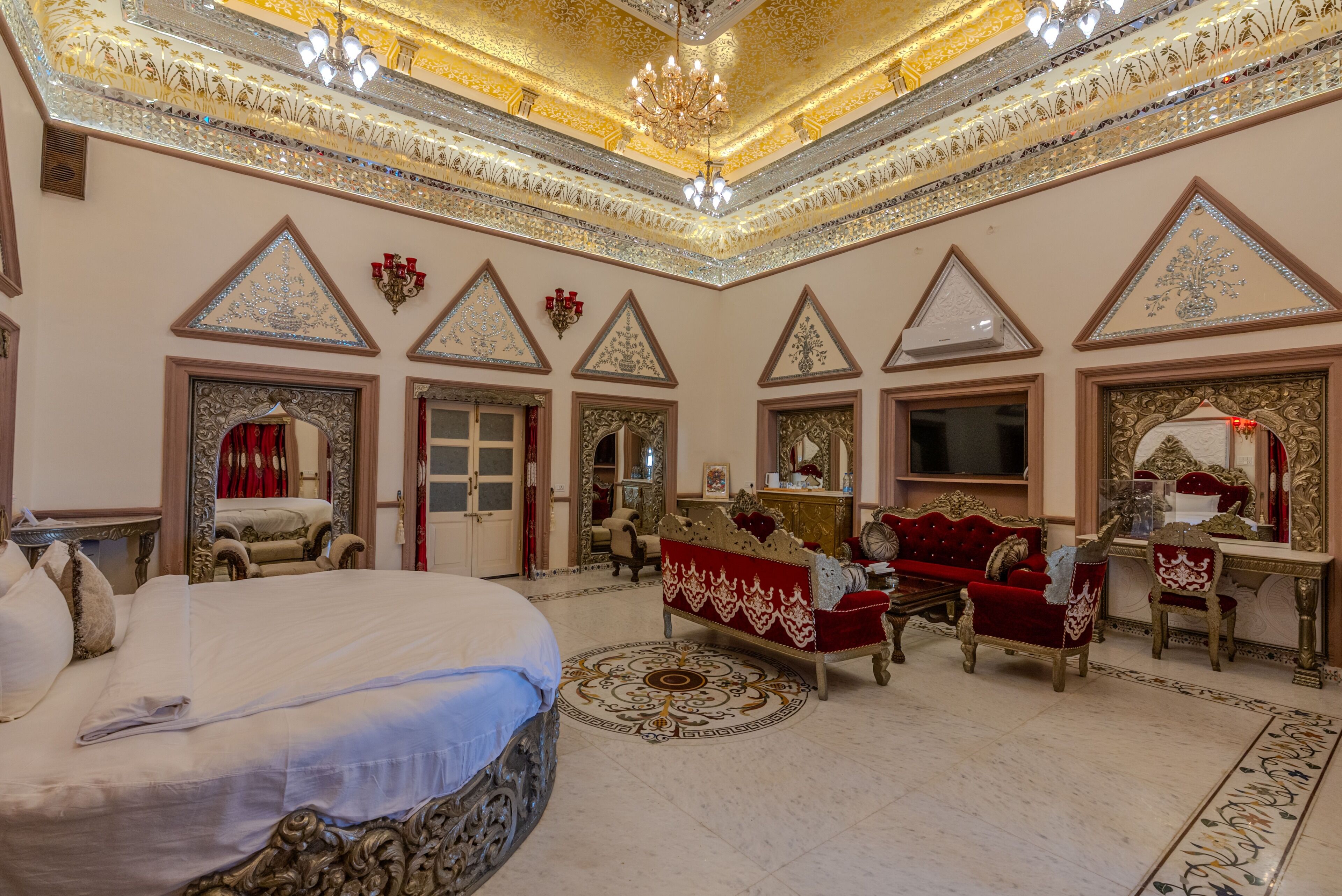 Una habitación lujosa con una cama grande, un sofá rojo y una televisión.