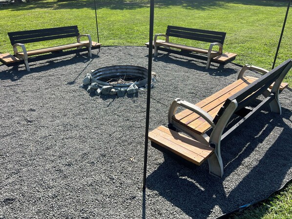 A circular seating area with benches and a fire pit.