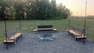 Un espacio al aire libre con bancos y un hogar para la chimenea.
