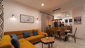Ein modernes Wohnzimmer mit einer Couch, einem Esstisch, Stühlen und einem Couchtisch.