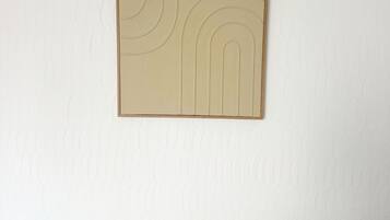 A wall with a textured pattern and a framed artwork.