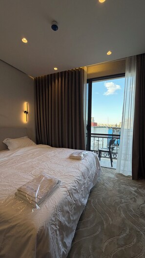 A hotel room with a bed, a view of the city, and a balcony. - 302 Tara-jre Jabal Al Lweibdeh With Stunning View (Amman)