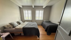A small, single-room with two beds, a bench, and a radiator. - Dream thatched house in a secluded location directly off Sylt. (Emmelsbüll-Horsbüll)