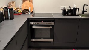 A modern kitchen with a built-in oven, a sink, and a countertop with various kitchen items. - Dream thatched house in a secluded location directly off Sylt. (Emmelsbüll-Horsbüll)