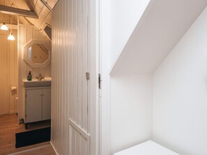 A modern bathroom with a wooden vanity, a mirror, and a towel rack. - 5 Star Holiday Home in Ansager (Ansager)