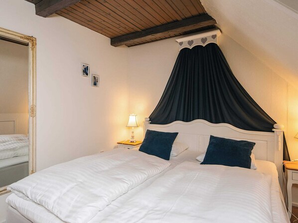 A double bed with a canopy, bedside tables with lamps, and a mirror. - 5 Star Holiday Home in Ansager (Ansager)