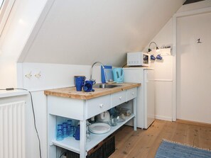 A compact kitchen with a wooden countertop, a sink, a microwave, and a refrigerator. - 5 Star Holiday Home in Ansager (Ansager)
