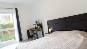 A bedroom with a large bed, a desk, and a chair. - Scenic Riviera Home Near sea (Grasse)