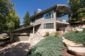 A modern two-story house with a stone facade, large windows, and a balcony. - Spacious 5BR, 5BA Deer Valley Nordic Village Haus—ideal mountain retreat for 12. (Park City)