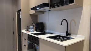 A compact kitchen with a built-in microwave, a coffee maker, and a dishwasher. - 304 Tara-jre Al Lweibdeh 2bdr With Stunning View (Amman)