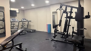A gym with treadmills, a bench press, and weight machines. - 304 Tara-jre Al Lweibdeh 2bdr With Stunning View (Amman)