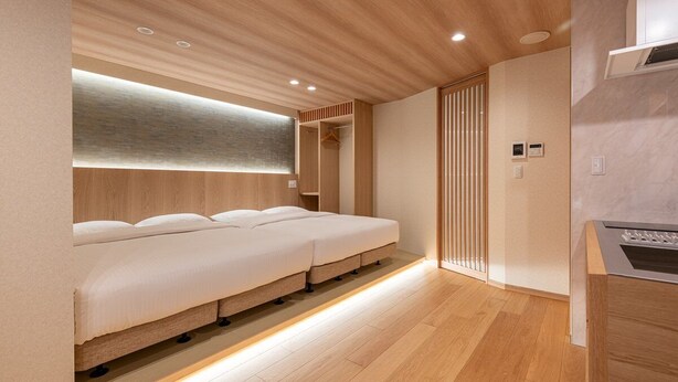 A modern hotel room with a wooden ceiling, a built-in bed, a small kitchenette, and a sliding door closet. - 【新築OPEN】浅草寺徒歩1分! 雷門20秒/檜風呂・Simmons/最大収容人数8名/渋谷新宿浅草 (Tokyo)