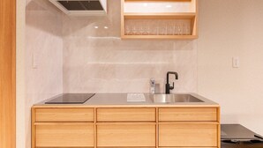 A kitchen with a stainless steel sink, wooden cabinets, a built-in shelf with glasses, and a ventilation hood. - 【新築OPEN】浅草寺徒歩1分! 雷門20秒/檜風呂・Simmons/最大収容人数8名/渋谷新宿浅草 (Tokyo)