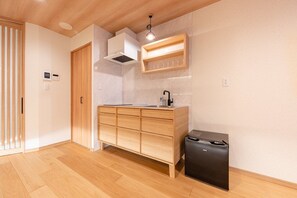 Een moderne keuken met houten kastjes, een inbouwoven en een zwarte koelkast.