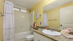 A bathroom with a bathtub, toilet, sink, and shower.