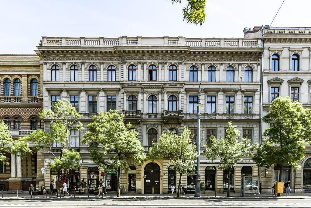 A multi-story building with classical architecture, featuring arched windows and a central entrance.