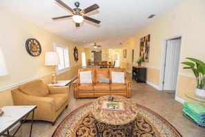 A living room with a sofa, coffee table, and a ceiling fan. - Private Spa, 2 seater golf cart, Life Style ID's (Lady Lake)