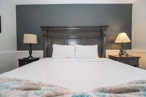 A neatly made bed with white linens, a dark wooden headboard, and two bedside tables with lamps. - Private Spa, 2 seater golf cart, Life Style ID's (Lady Lake)