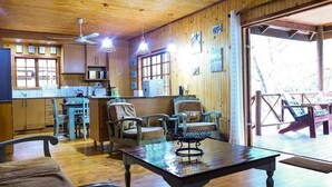 Un intérieur en bois comprenant un coin repas, une cuisine et un espace salon.