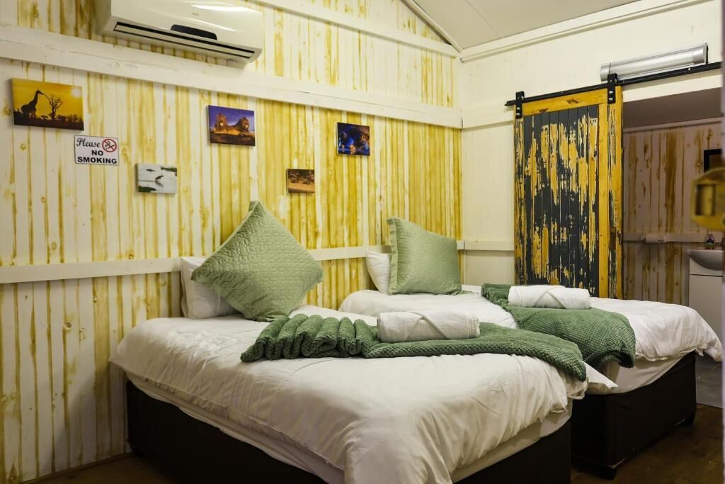 Ein Zimmer mit zwei Betten, einem Rauchverbot-Schild und einem gelb-schwarz gestreiften Vorhang.