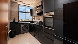 Una cocina moderna con lavadora integrada, horno y un amplio ventanal con vistas a la ciudad.