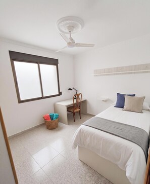 A bedroom with a bed, a desk, a chair, a ceiling fan, and a window. - Sunrise overlooking the sea: townhouse with terraces, views and swimming pool (Playa de Puzol)