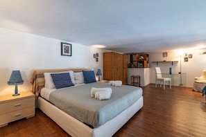 A bedroom with a bed, bedside tables, a wardrobe, a desk, and a chair. - Elegant 57 dqm apartment, for up to 4 guests, located on the second floor of a renovated period building with lift (steps to access). The property is located in the center of Palermo, in an authentic and folkloristic neighborhood in the Vucciria area, th (Palermo)