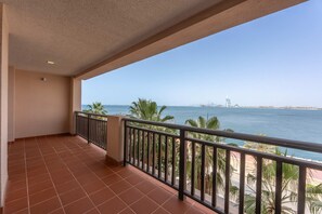 Ein Balkon mit Blick auf das Meer und Palmen.
