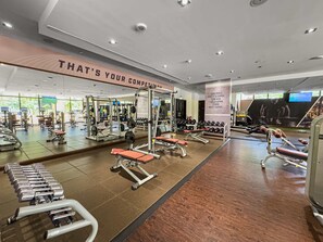Ein Fitnessstudio mit Krafttrainingsgeräten, Spiegeln und motivierenden Postern.