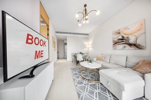 Ein modernes Wohnzimmer mit einer Couch, einem Couchtisch, einem Fernseher und einem Schild mit der Aufschrift 'BOOK ME'.